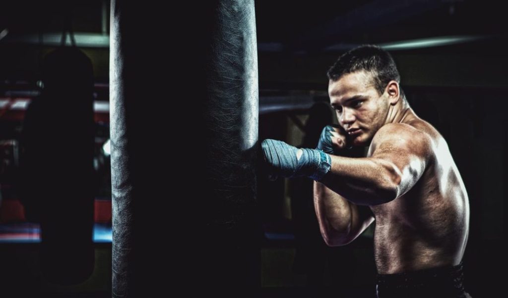 Bokser met bokspads tijdens training - essentieel voor veilig boksen