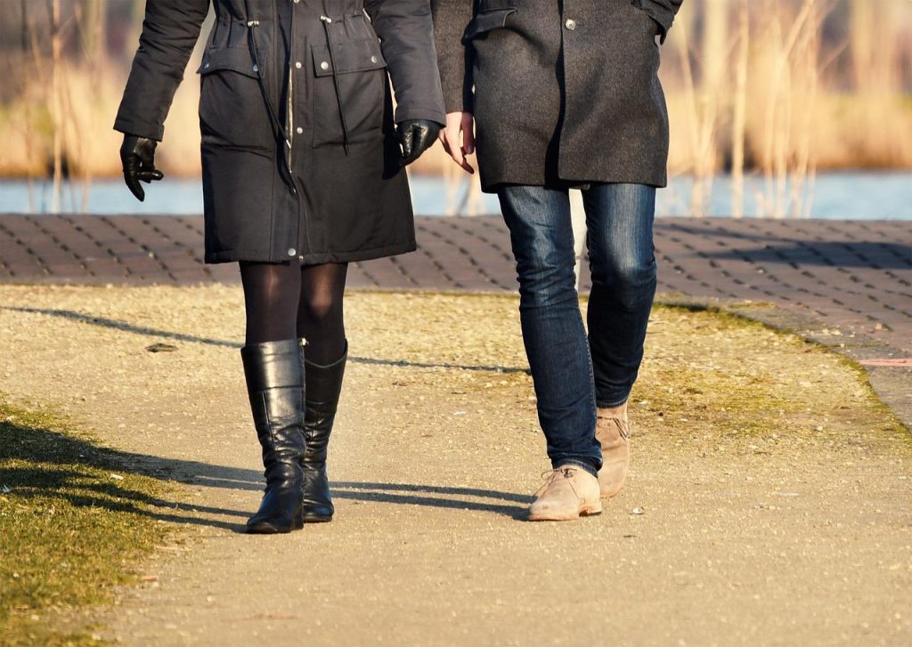 Vrouw toont hoe ze laarzen met een brede schacht stijlvol draagt, gecombineerd met jeans en accessoires